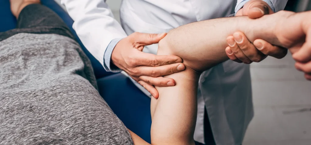 Physical therapist examining a patient’s hand during a rehabilitation session.