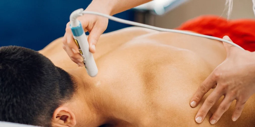 a male patient is getting laser therapy treatment
