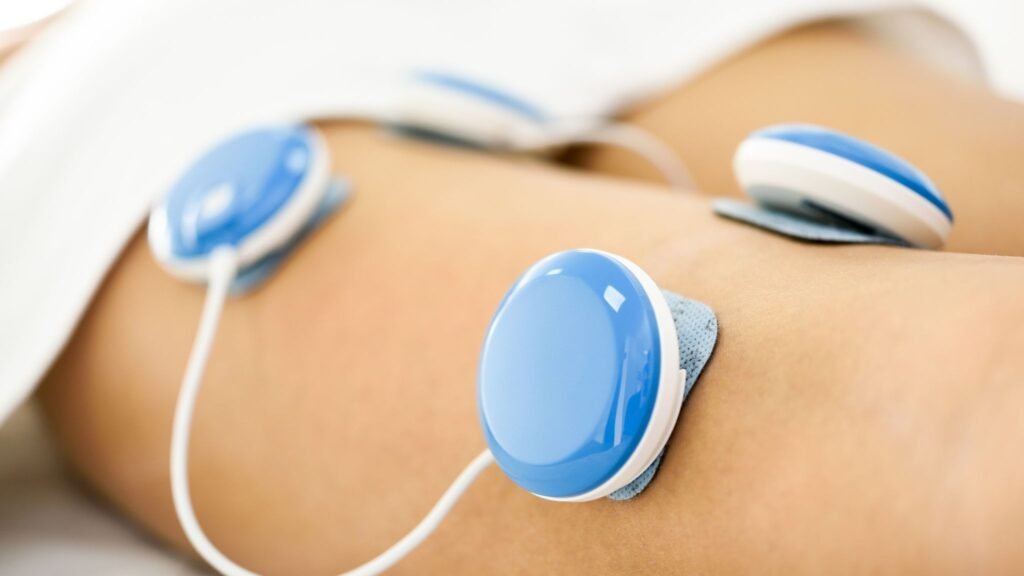 Person receiving Interferential-Electro-therapy treatment with electrodes on their leg.