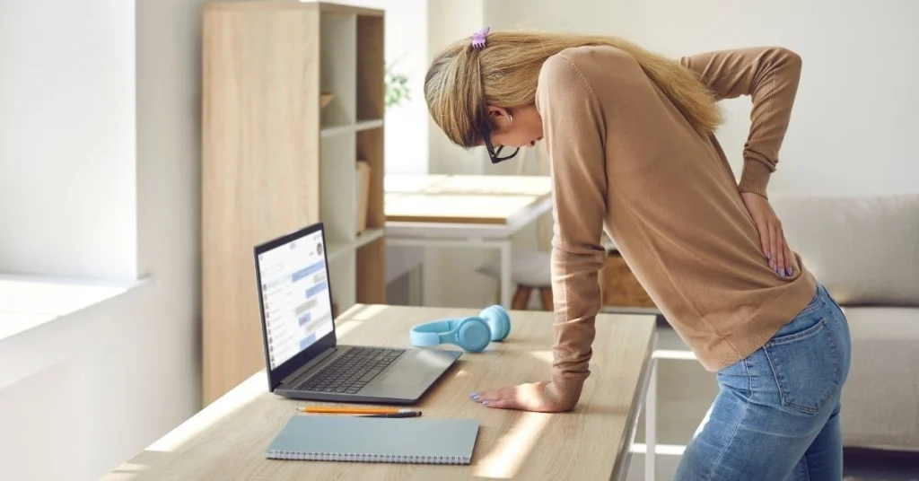 woman-experiencing-chronic-lower-back-pain-while-working-on-laptop-at-home-office-desk