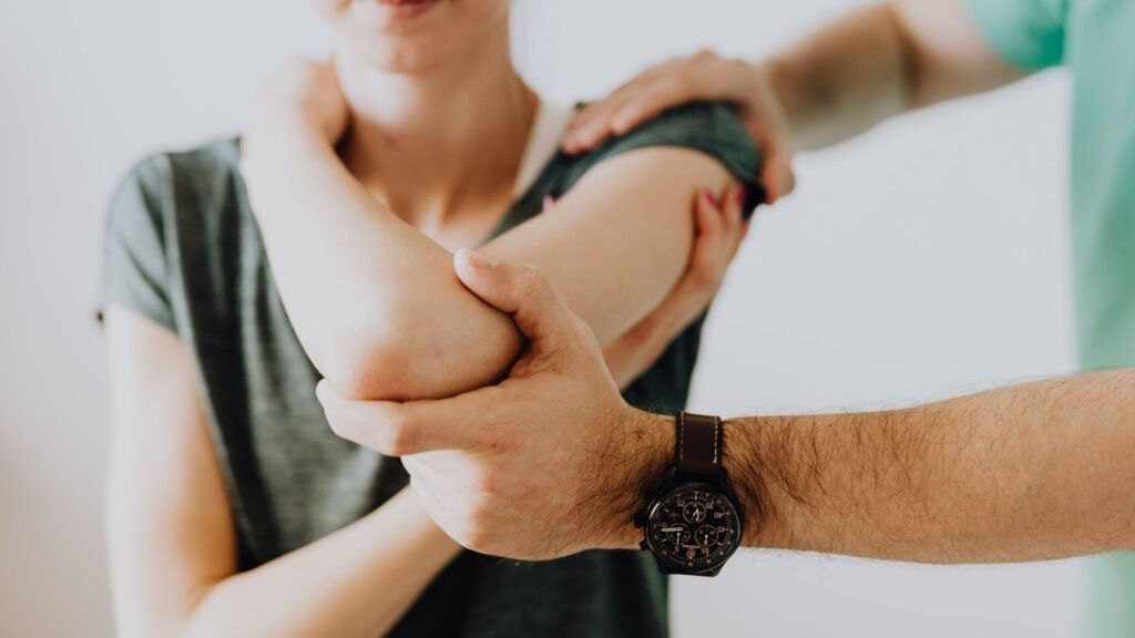 A person receiving a shoulder massage from another individual.