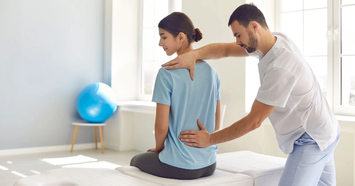 chiropractor-assessing-a-female-patient-s-lower-back-posture