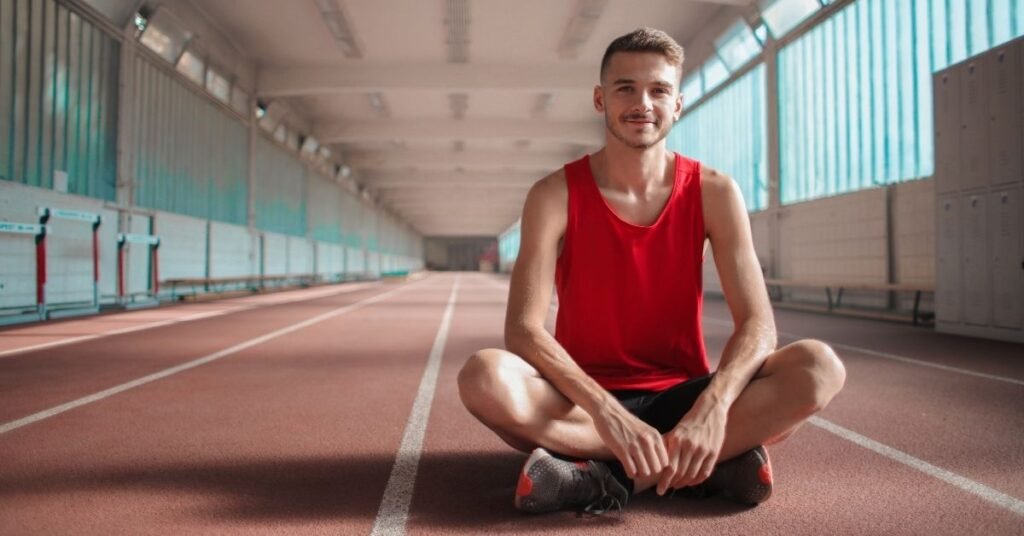 athlete-resting-on-an-indoor-track-after-training
